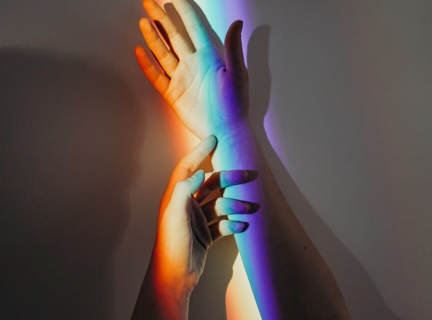 persons hands with rainbow colors